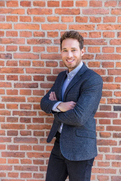 Businessman portrait on brick wall background. Young confident smiling man standing arms crossed, looking at camera — Stock Photo, Image