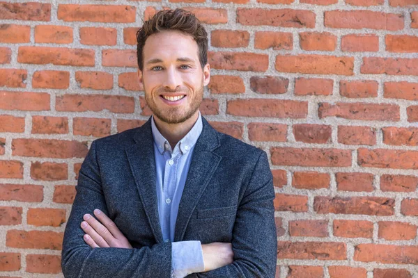 Businessman portrait confident young business entrepreneur man looking at camera against urban brick wall texture. Smiling caucasian male adult — Stock Photo, Image