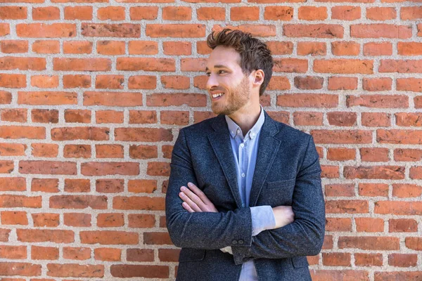 Αυτοπεποίθηση επιχειρηματίας άνθρωπος νέος επιχειρηματίας κοιτάζοντας προς το πλαϊνό πορτρέτο κατά της πόλης γραφείο τούβλο τοίχο φόντο. Χαμογελώντας καυκάσιος επαγγελματίας σε smart casual σακάκι — Φωτογραφία Αρχείου