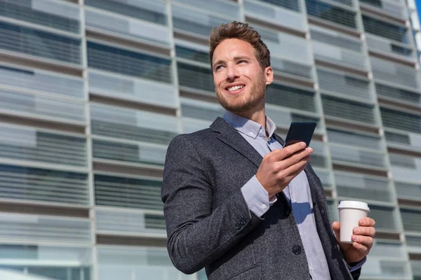 Office work man looking away businessman holding mobile cell phone. Young urban professional man using smartphone at office building. Career job opportunity concept — Stock Photo, Image