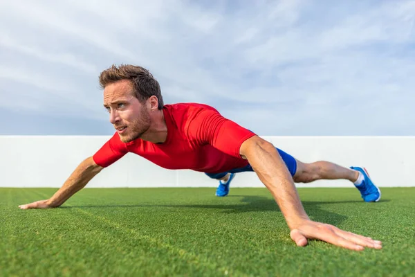 Wide grip pushup push-up variation advanced chest exercise demonstration by male trainer athlete man training at outdoor gym — Stock Photo, Image