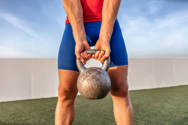 Kettlebell levantamiento de pesas ajuste hombre levantamiento de peso crossfit en el gimnasio al aire libre para entrenamiento en cuclillas pierna — Foto de Stock