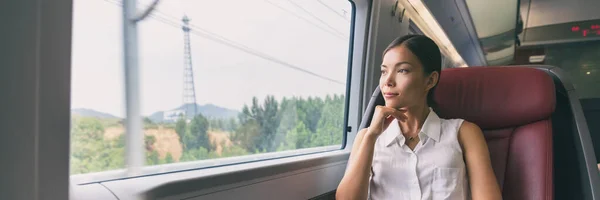 Voyage en train asiatique femme d'affaires regardant par la fenêtre contemplative le matin pour se rendre au travail bannière panorama gens style de vie. Femme d'affaires dans un siège de première classe — Photo