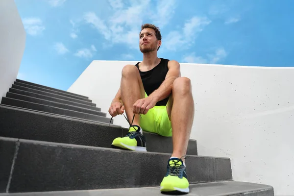 Δρομέας άνθρωπος ετοιμάζεται να εκπαιδεύσει εξωτερική στις σκάλες της πόλης γυμναστήριο έξω δένοντας αθλητικά κορδόνια κατάρτισης καρδιο προπόνηση άσκηση στις σκάλες. Acitve υγιή τρόπο ζωής αθλητισμού κίνητρο γυμναστικής αθλητή — Φωτογραφία Αρχείου