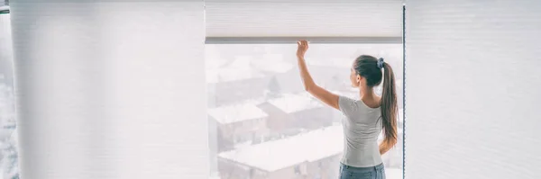 Casa estilo de vida mujer que se queda en persianas de apertura sombras ventana tratamiento celular panal plisado papel cortinas banner fondo — Foto de Stock