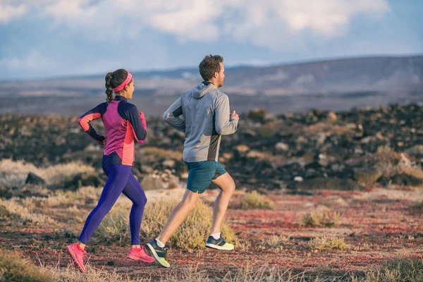 Ejecutar personas entrenando juntos pareja activa estilo de vida saludable trotar en otoño al aire libre. Feliz hombre y mujer amigos ejercitando fuera — Foto de Stock