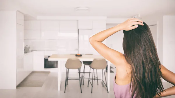 Stresli bir kadın bahar temizliği ya da ev dekorasyonu için mutfak dairesine bakıyor. Yeni emlak projesinde apartman dairesi seçimi sona eriyor — Stok fotoğraf