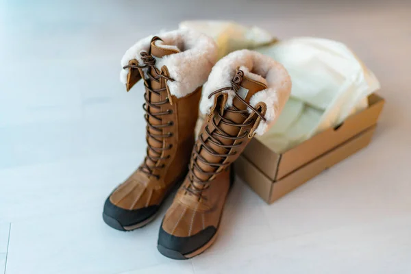 Nya vintervandringskängor med öppen skokartong som köper nya skor på nätet hemifrån. Lång vattentät läder och fårskinn lyxskor för vintern — Stockfoto