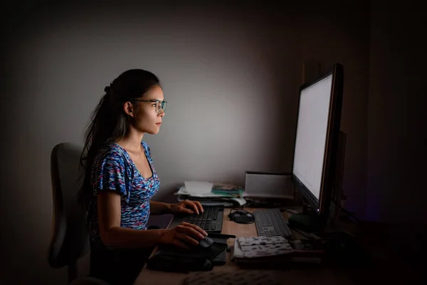 Working late at night on computer. Asian woman at office desk staring at desktop screen wearing blue light eyewear glasses to protect from eye strain for long hours of work — Stock Photo, Image