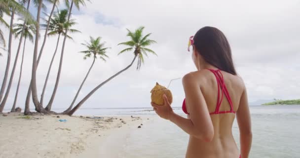 Beach διακοπές μπικίνι Ασιατική κοπέλα πίνοντας υγιεινό νερό καρύδας από φρέσκα φρούτα — Αρχείο Βίντεο