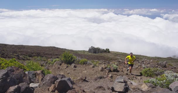 トレイルランニングマン-雲の上の山道を走る男性アスリート — ストック動画
