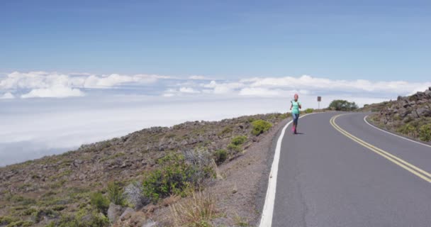 Femme de course - athlète coureuse jogging sur la route de montagne au-dessus des nuages — Video