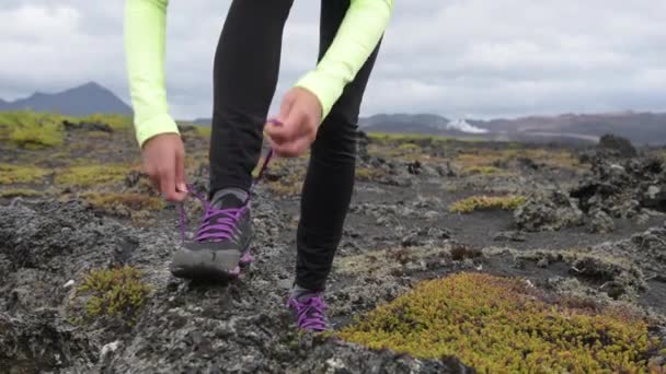 Стежка біжить спортсменка, зав'язуючи шнурки взуття, готуючись до тренувань — стокове відео