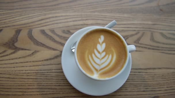 Koffie Cappuccino cup bovenaanzicht met koffie latte kunst in cafe — Stockvideo