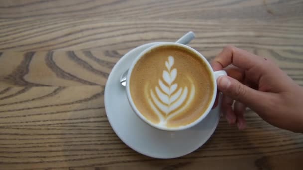 Kaffe Cappuccino kopp ovanifrån med kaffe latte konst i café — Stockvideo