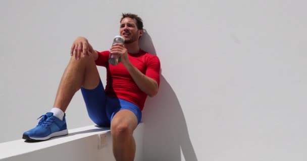 Uomo corridore acqua potabile dalla bottiglia dopo l'allenamento stanco esausto — Video Stock