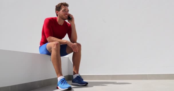 Atleet man praten over de telefoon thuis na het trainen — Stockvideo