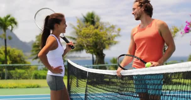 テニス-女性と男性のテニス選手がテニスコートで試合後にネットで話しています — ストック動画