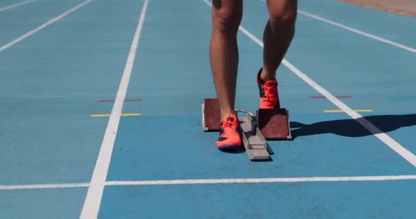 Athlétisme Runner prêt à courir sur la ligne de départ de la piste en blocs de départ — Video