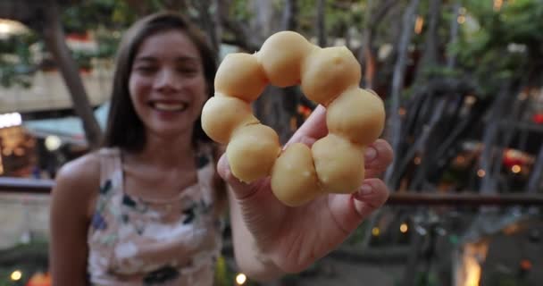 Pączki Mochi, Pon de Ring Donuts, japońska przekąska. Kobieta pokazująca i jedząca lokalne jedzenie w Honolulu, Oahu, Hawaje — Wideo stockowe