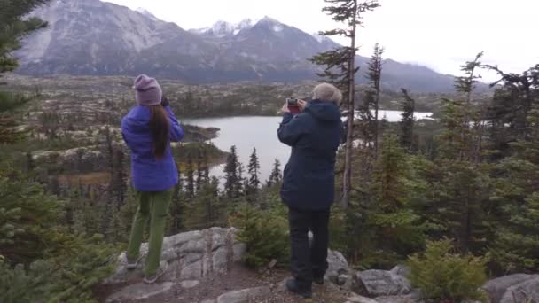 Yukon landskap med människor vandrar på resor lever utomhus livsstil. Resenärer på vandring tar bilder på fjällandskapet på hösten. Turister från Alaska kryssningsfartyg utflykt — Stockvideo