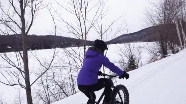 Fett cykel på vintern. Fet cyklist cykla i snön på vintern. Kvinna lever hälsosam utomhus aktiv livsstil — Stockvideo