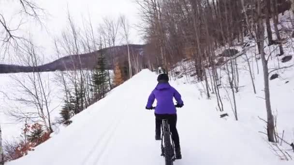 Fat bike in winter. Fat biker riding bicycle in the snow in winter. Woman living healthy outdoor active lifestyle — Stock Video