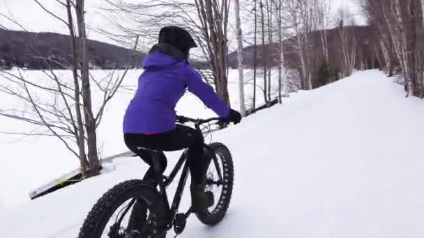 겨울 엔 뚱보 자전거. 겨울에는 눈 속에서 자전거를 타고 다닌다. 야외에서 건강 한 겨울 스포츠 생활을 하는 여성 — 비디오