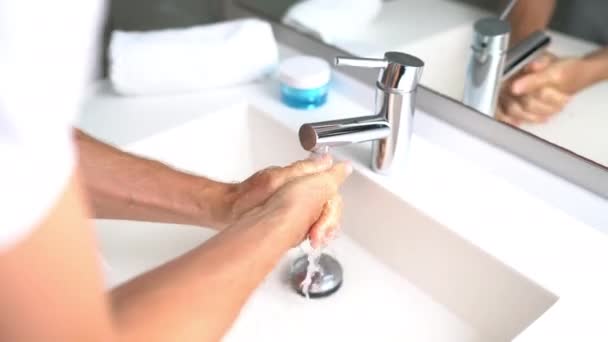 Lavarse las manos con agua caliente y jabón en casa fregadero de baño hombre limpieza de la higiene de las manos para la prevención de brotes de coronavirus. Protección pandémica del virus Corona lavándose las manos con frecuencia — Vídeos de Stock