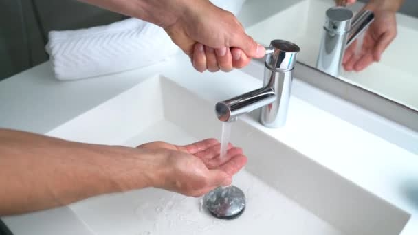 Homem lavar as mãos na pia do banheiro em casa verificando a temperatura com a mão — Vídeo de Stock