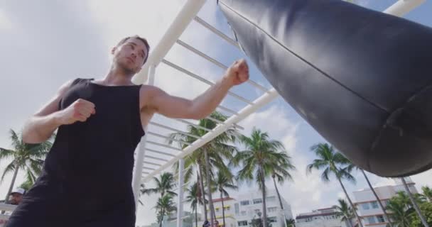 Fitness homem treinamento boxe perfurando saco pesado no ginásio ao ar livre — Vídeo de Stock