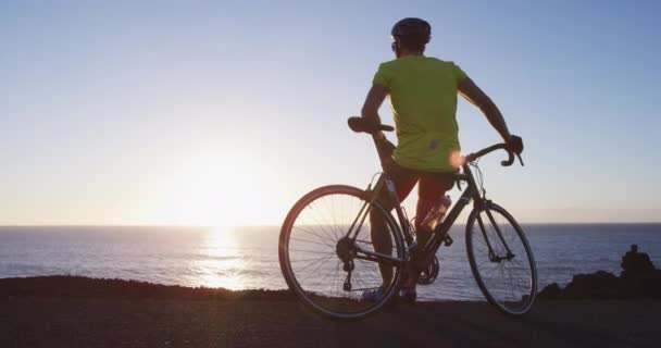 Cycliste homme relaxant sur vélo de route en regardant le coucher du soleil et après le vélo — Video