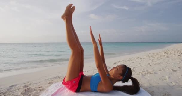 Fitness vrouw training uit te werken op het strand buiten doen teen touch crunches — Stockvideo