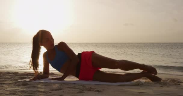 Fitness kadını yan yatar bacak kaldırma egzersizi yapar bacak kaldırma kuvveti alıştırması yapar — Stok video