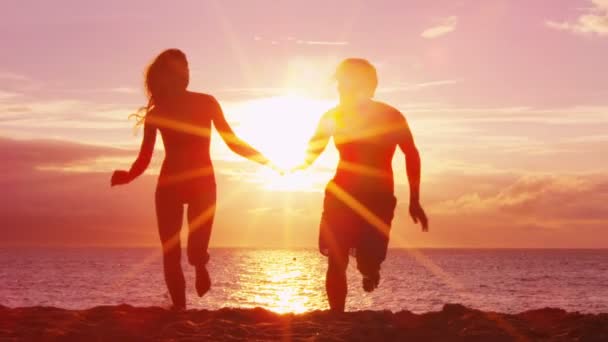 Romántico atardecer playa pareja cogida de la mano en la playa corriendo divertirse en los viajes — Vídeos de Stock