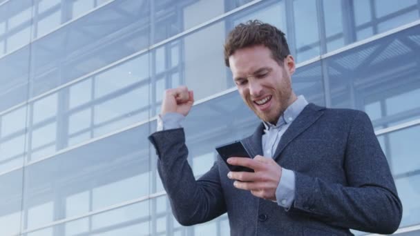 Успіх і досягнення - щасливий бізнесмен вітає погляд на мобільний телефон — стокове відео