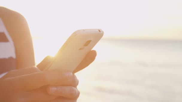Ponsel - Pintar wanita sms menggunakan aplikasi di pantai — Stok Video