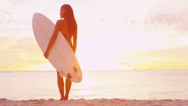 Vacaciones de viaje surf - mujer surfista mirando la puesta de sol de la playa del océano — Vídeo de stock
