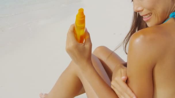 Güneş kremi süren Asyalı kadın omzunda sprey şişesiyle güneş kremi sürüyor. — Stok video
