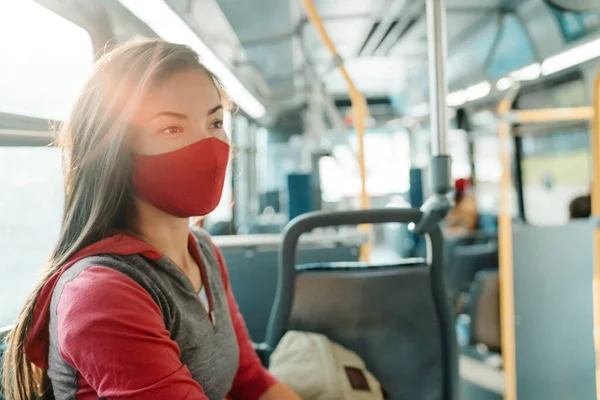 Mujer con mascarilla en el interior del autobús de transporte público viajando al trabajo. Asiática chica pasajero sentado con rojo facial tela cubierta. —  Fotos de Stock