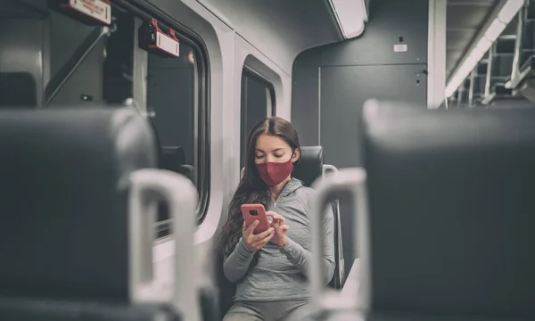 Trein passagier met behulp van mobiele telefoon tijdens het woon-werkverkeer dragen gezichtsmasker voor coronavirus pandemie. Panoramische banner van mensen levensstijl pendelen na het werk 's nachts. — Stockfoto