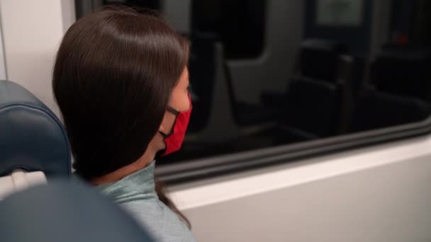 Donna che indossa maschera facciale nei trasporti pubblici durante la pandemia di coronavirus Covid-19. Concetto maschera viso con pendolare trasporto treno. Passeggero donna multirazziale utilizzando maschera facciale sul pendolarismo. — Video Stock