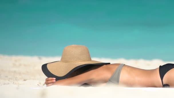 Suntanning Νεαρή γυναίκα είναι ηλιοθεραπεία στην παραλία - καλοκαιρινές διακοπές Concept — Αρχείο Βίντεο