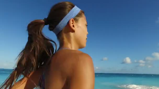 Laufmädchen joggt am Strand vor blauem Himmel - Läuferinnen-Workout — Stockvideo