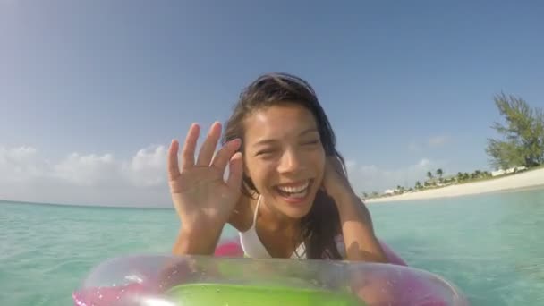 Mulher se divertindo na praia na água em flutuadores de piscina — Vídeo de Stock
