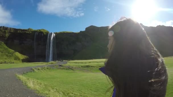 Vrouw toeristisch wandelen door waterval op IJsland — Stockvideo