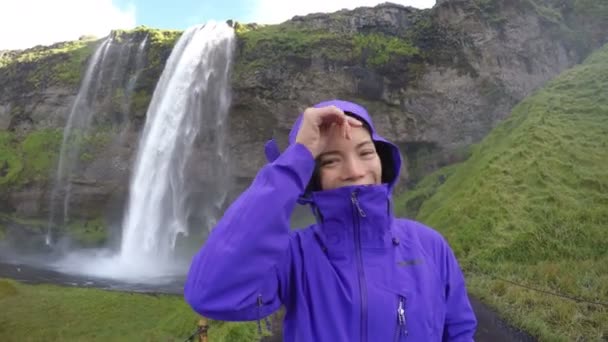 Glad kvinna njuter av spektakulära vattenfall Island — Stockvideo