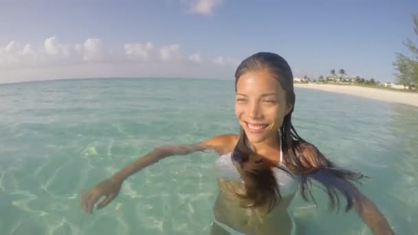 Donna sorridente che nuota nell'oceano sulla spiaggia — Video Stock