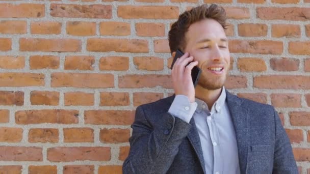 Empresario hablando de negocios en el teléfono que sostiene el teléfono inteligente en la calle de la ciudad — Vídeo de stock