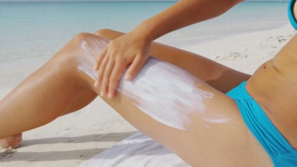 Femme de plage appliquant de la crème solaire sur le corps - protection solaire — Video